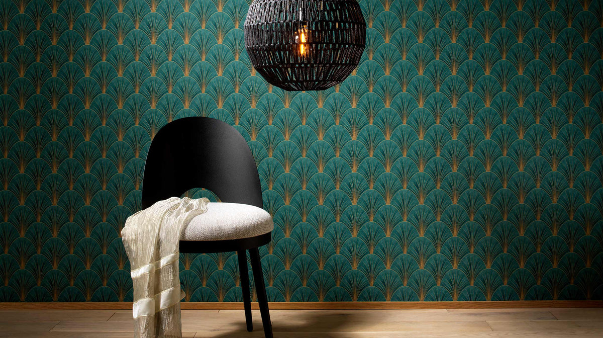 Erismann Elle Decoration Art Deco fan wallpaper in deep green and gold tones styled with a chair and pendant lighting in a modern interior