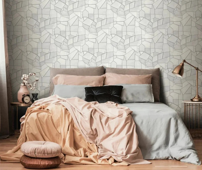 Erismann Elle Decoration 4 light grey geometric wallpaper with textured panels and structured design behind a large bed 