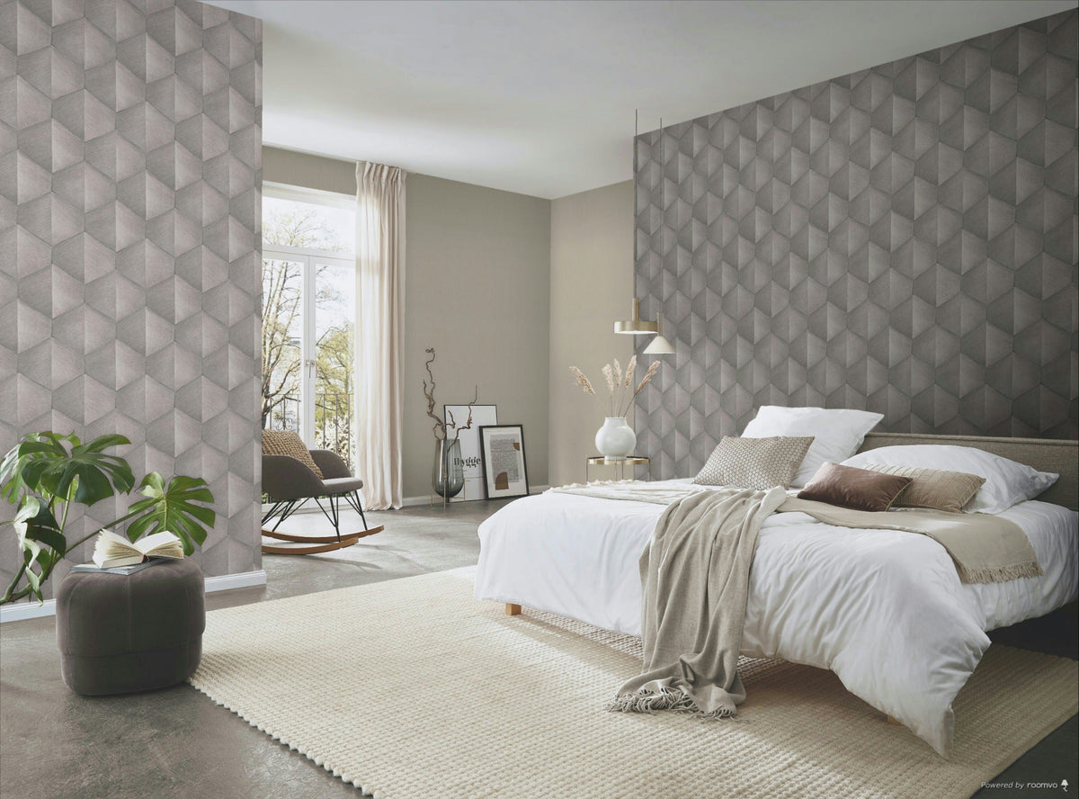 Erismann Fashion For Walls 4 10370-38 wallpaper in a serene bedroom with a geometric feature wall behind the bed, pendant light and side table with a vase, textured rug, rocking chair by the window, and a leafy plant.