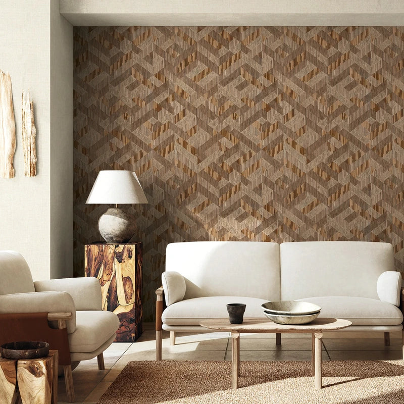 Marburg Boho 35790 Beige and brown geometric wallpaper on a feature wall in a living room, shown behind a light sofa with an armchair, wood coffee table, and a table lamp.
