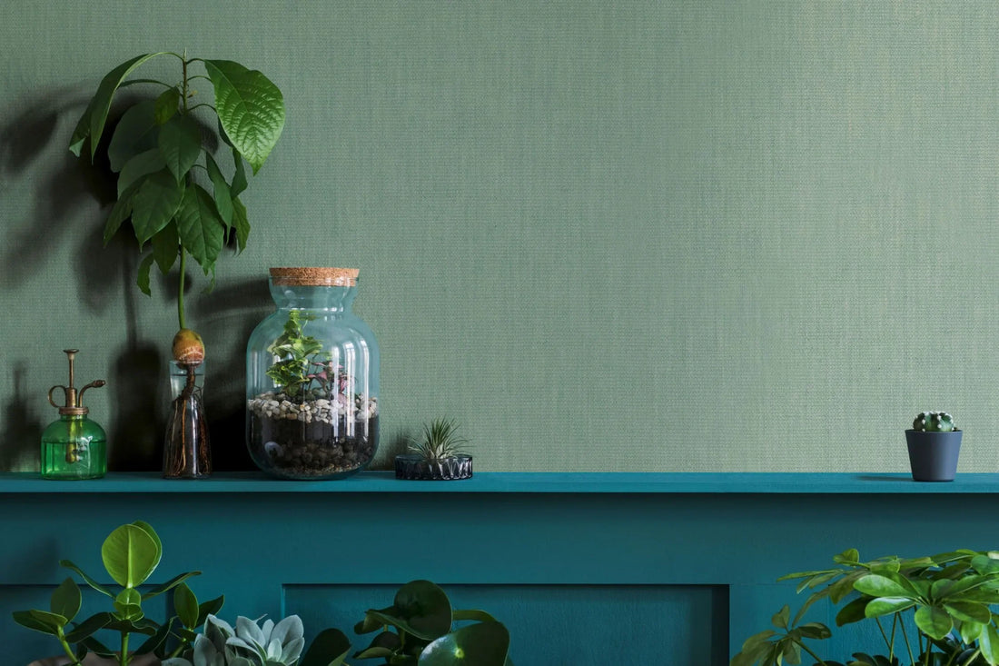 Marburg Botanica 33331 A green textured wallpaper roll partially unrolled on a matching surface, showing a fine woven-look pattern.