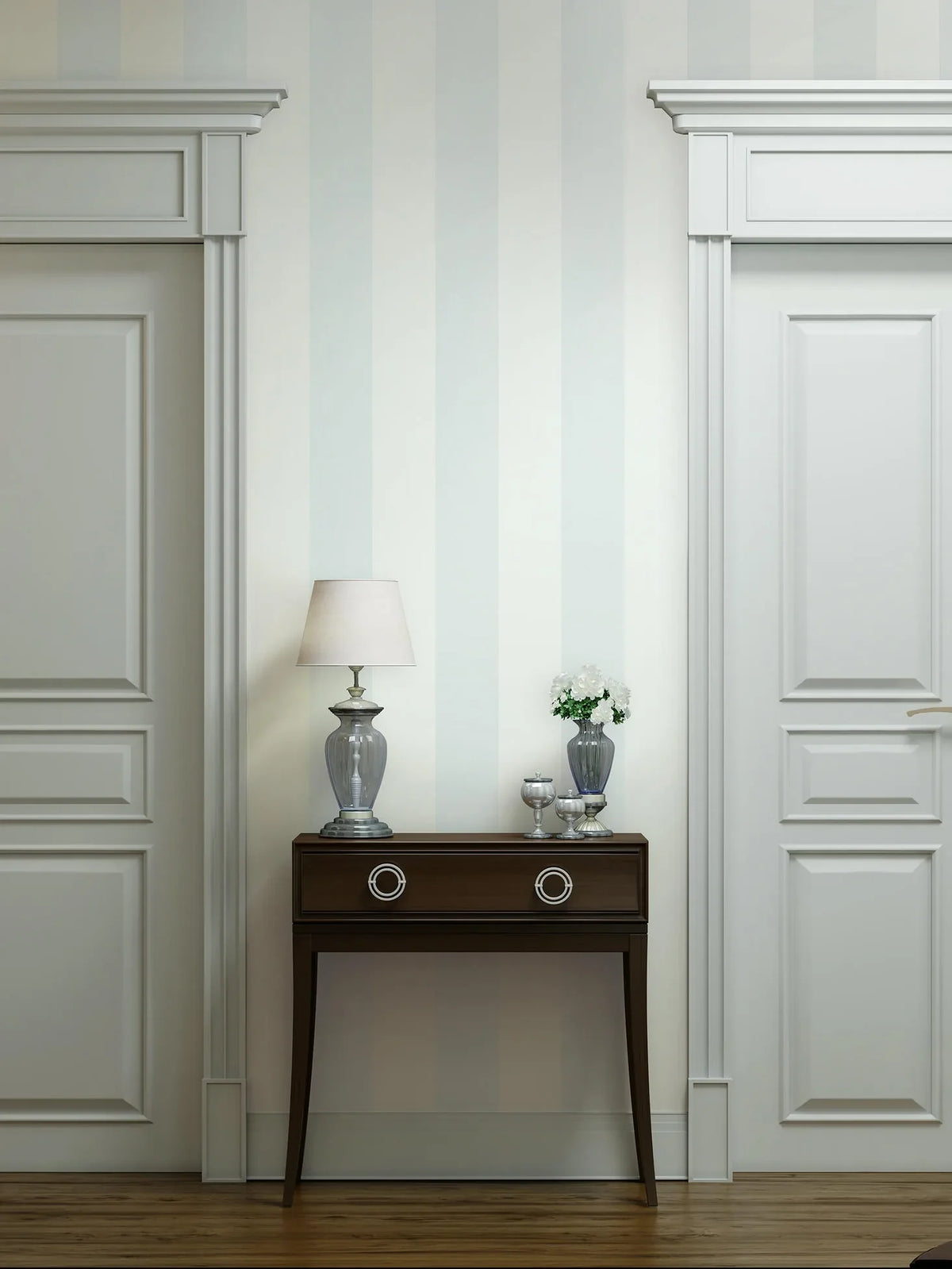 Marburg 47635 wallpaper lounge feature wall with soft vertical stripes, dark wood console between paneled doors, glass lamp and vase of white flowers, calm classic feel.