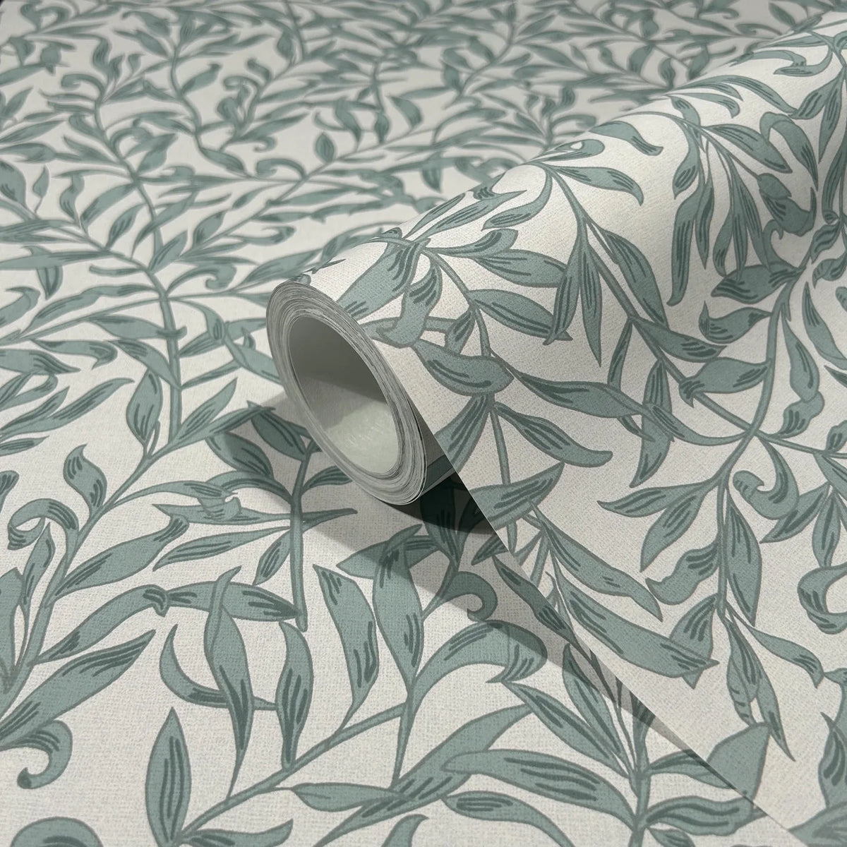 Marburg 47639 wallpaper close-up of rolled sample with green botanical vine pattern on a light background.