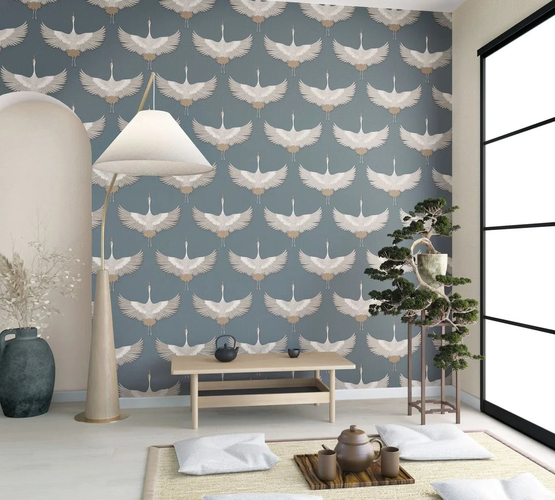 Marburg Kumano 34531 wallpaper with soaring cranes on a dusty blue linen-like background.
