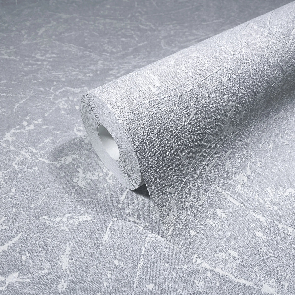 Marburg Loft Superior 34153 A gray wallpaper roll with a textured, abstract pattern of irregular light streaks resting on a matching unrolled sheet.