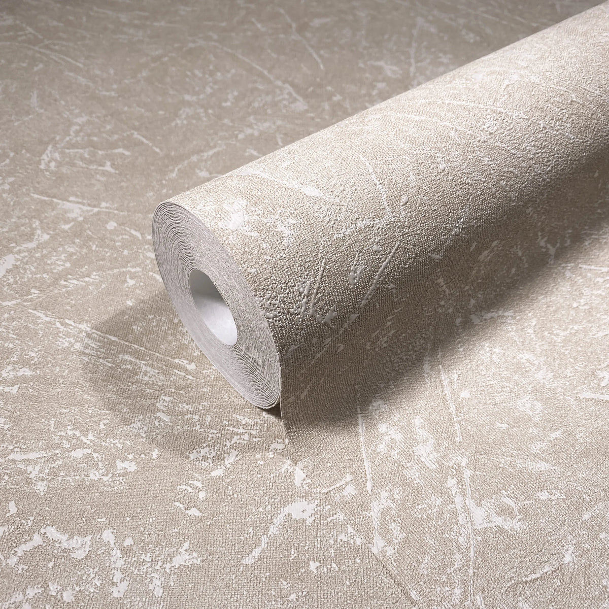 Marburg Loft Superior 34154 Beige textured wallpaper roll with irregular white distressed markings, shown resting on a matching unrolled sheet.