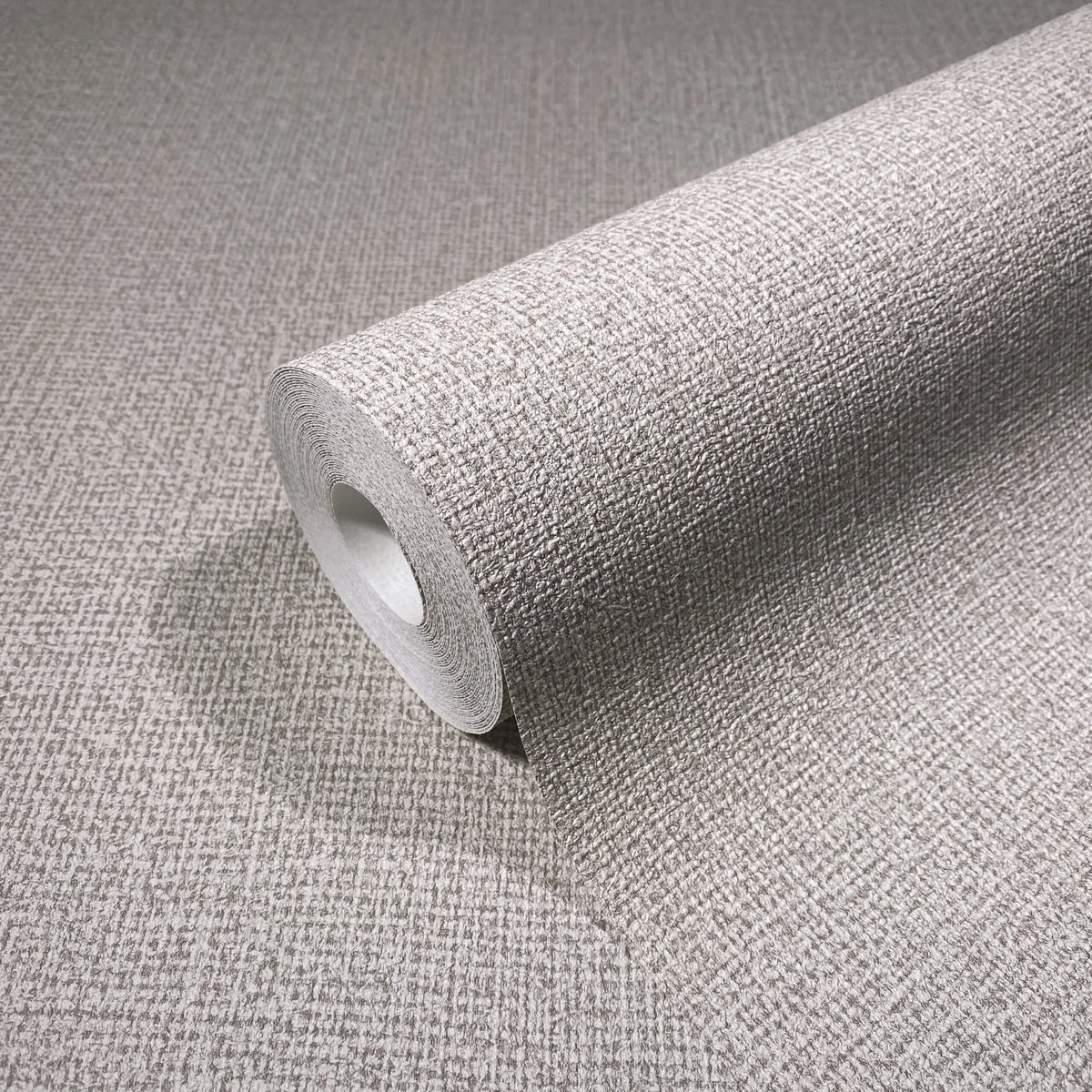 Marburg Loft Superior 34176 Close-up of a wallpaper roll with a textured crosshatch pattern resting on matching unrolled wallpaper.