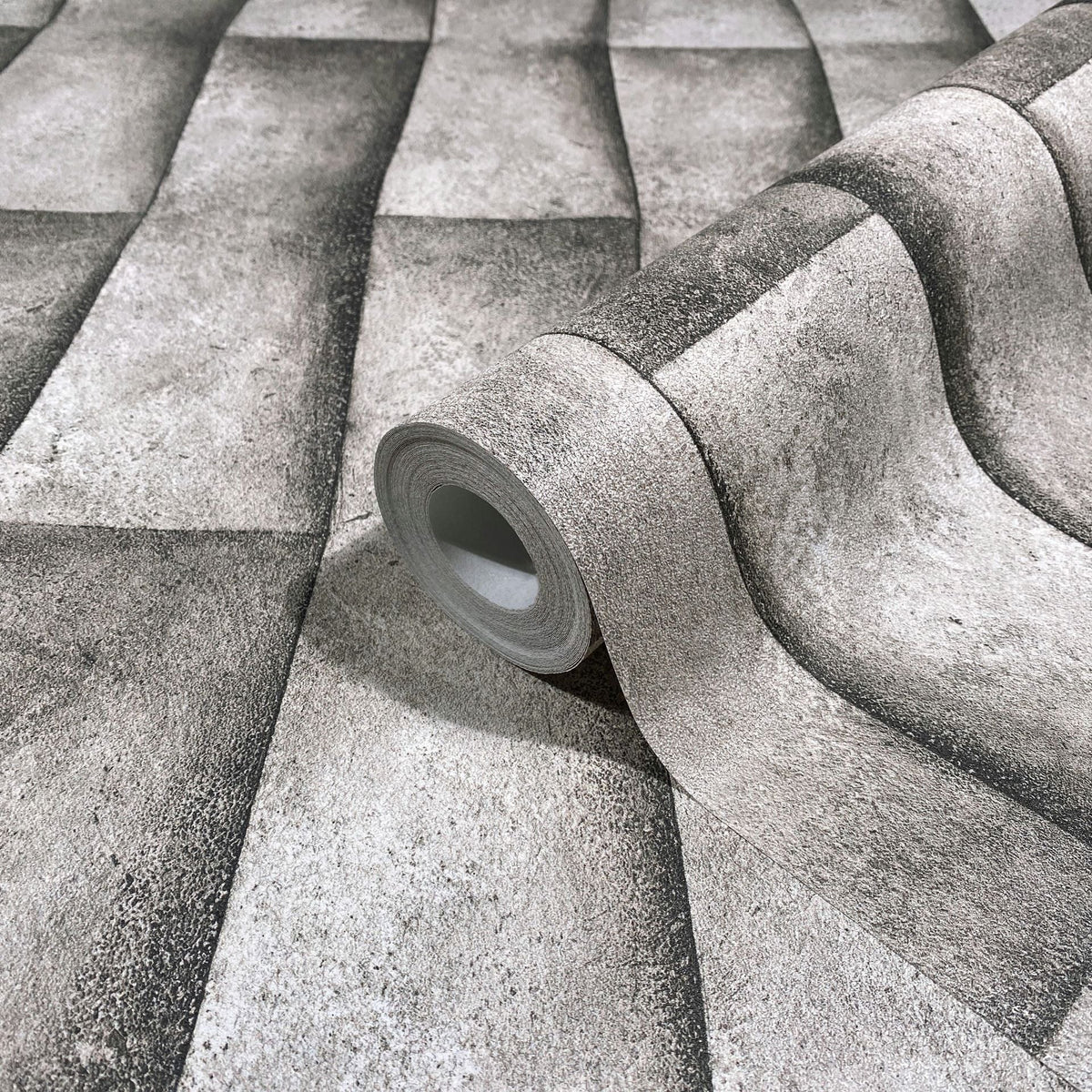 Marburg Novamur Mona 81650 Wallpaper roll shown on matching surface with a shaded rectangular block pattern that forms a 3D wavy effect in grey-beige tones.