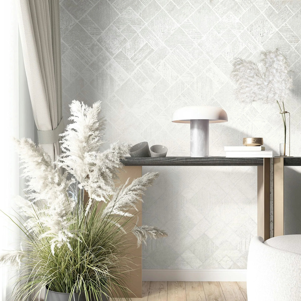 Marburg Ritus 35508 Light geometric wallpaper with a subtle square-and-diamond grid behind a console table holding a dome table lamp, small bowls, and stacked books, with pampas grass, a curtain, and part of an upholstered chair in view.