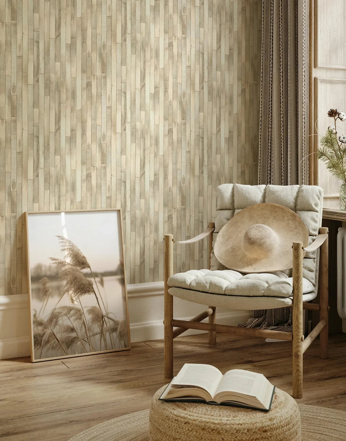 Marburg Struktura 45734 Beige vertical wood plank–effect wallpaper in a cozy living room corner with a cushioned wooden chair holding a sun hat, a framed print leaning against the wall, a pouf with an open book, and a window with curtains.
