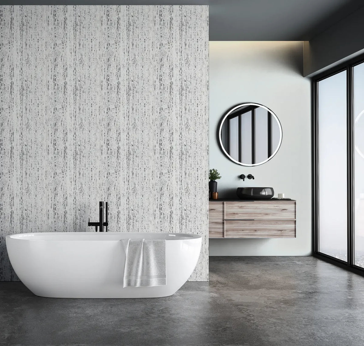Marburg Travertino 33352 Gray and white vertically streaked wallpaper forms a feature wall behind a freestanding bathtub in a modern bathroom with a floating vanity, round mirror, and large windows.