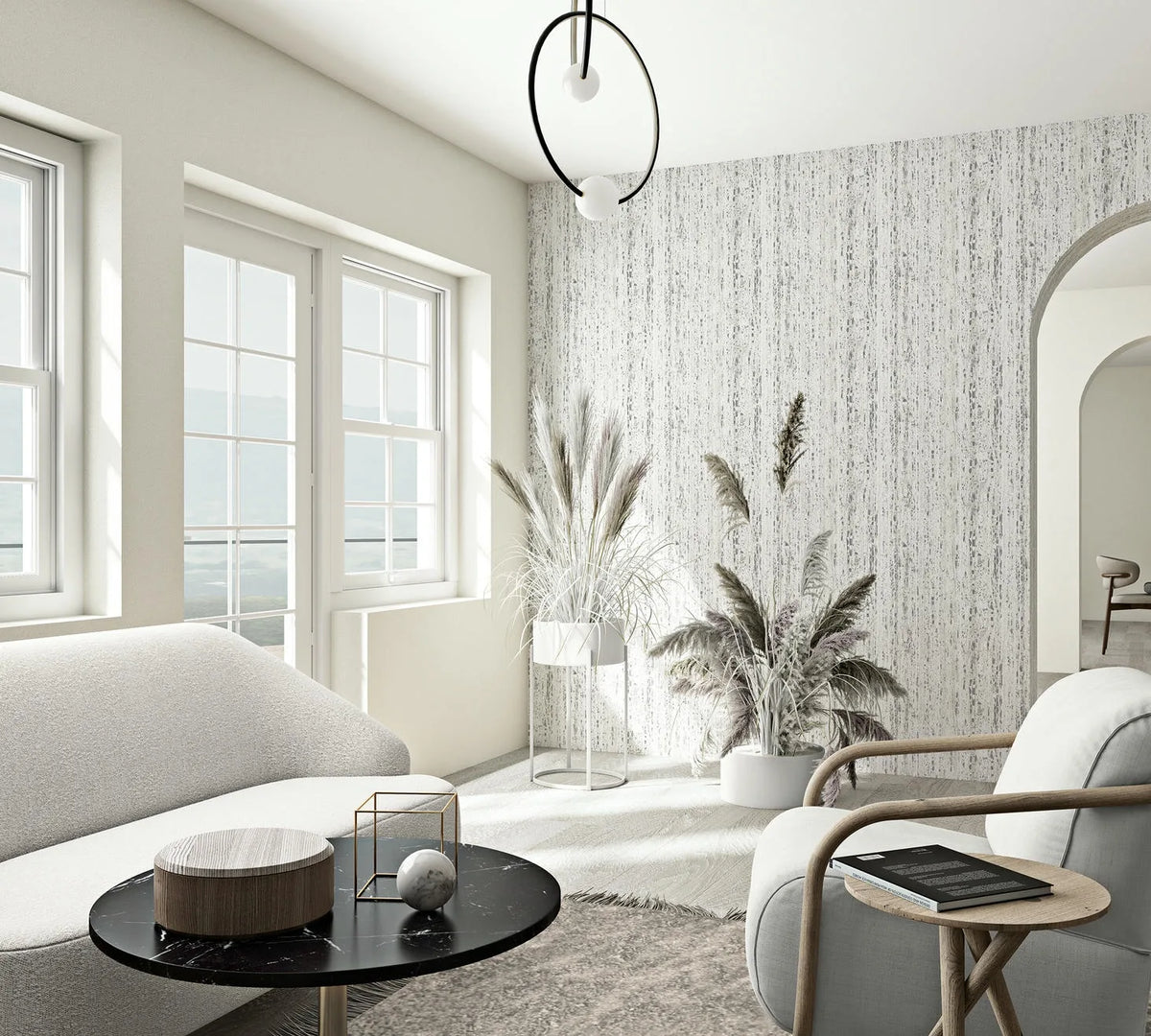 Marburg Travertino 33352 Bright living room featuring a gray and white vertical streak wallpaper on a feature wall behind potted grasses, with a sofa, armchair, round coffee table, large windows, and an arched doorway.