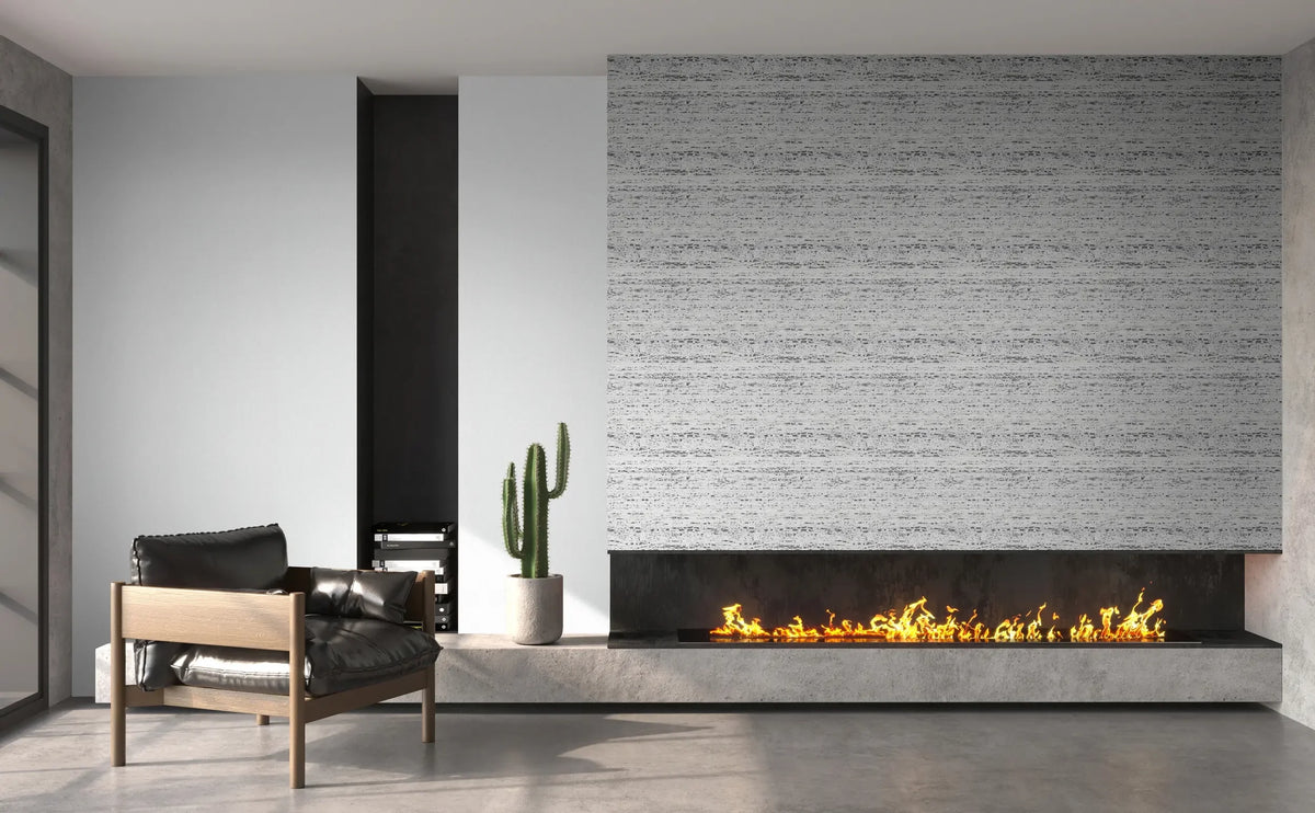 Marburg Travertino 33352 Living room scene showing gray and white horizontally striated wallpaper above a long linear fireplace, with an armchair, a potted cactus, and books on a concrete bench.
