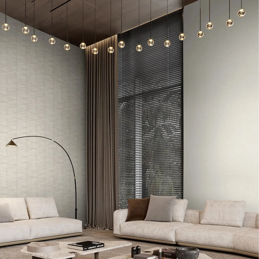 Marburg Travertino 33367 Wide living room scene showing light beige wallpaper; the left wall has a subtle small‑scale geometric triangle pattern and the adjacent wall is a plain textured surface. Two sofas, low coffee tables, an arc floor lamp, long curtains, window blinds, a rug, and.