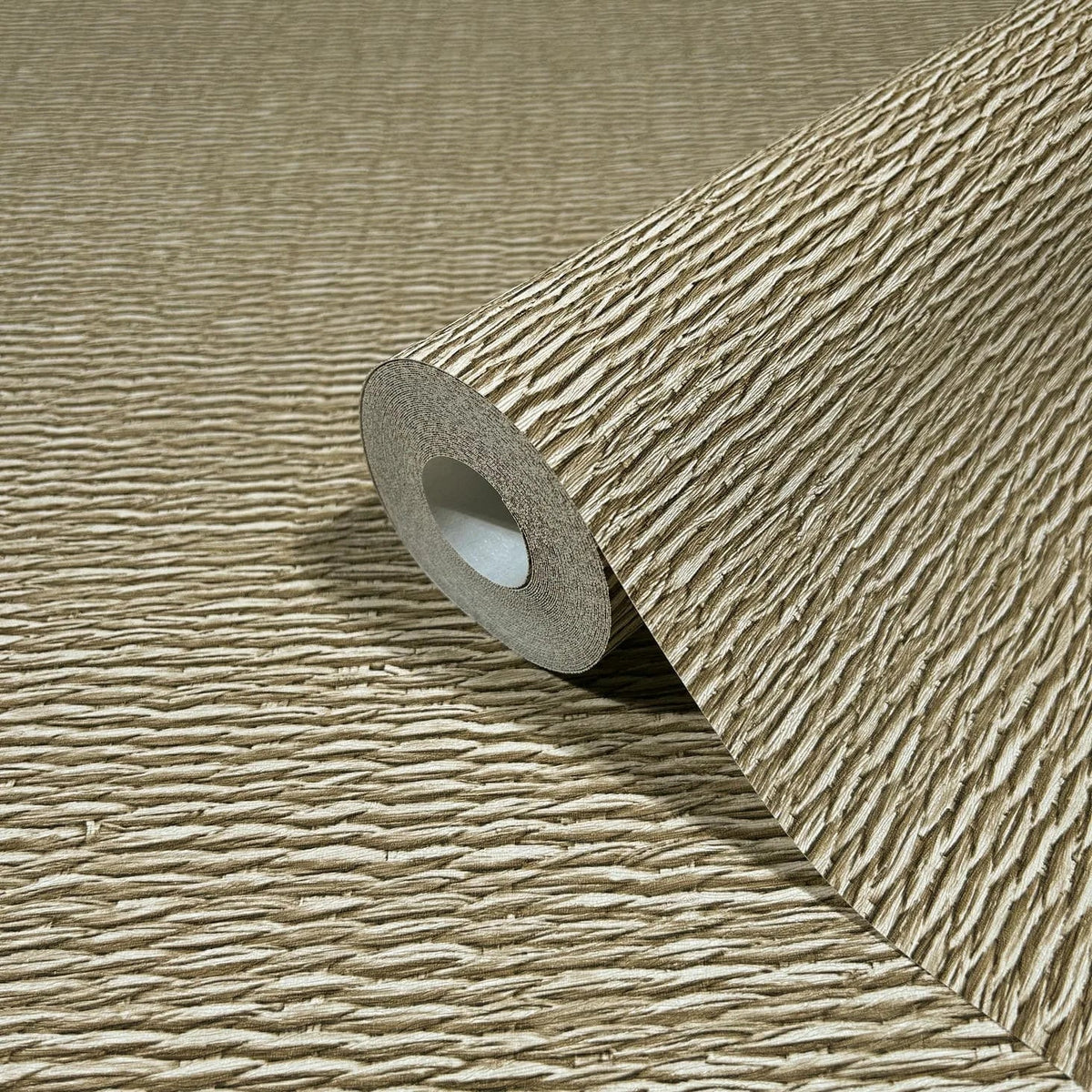 Marburg Travertino 33384 Close-up of a beige wallpaper roll with horizontal ridged texture, resting on the same unrolled wallpaper.